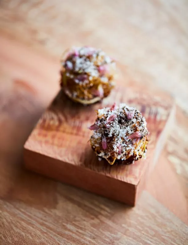 A close up of a delicate dish at restaurant St. Barts served on a small square board.