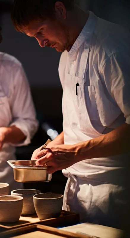 Two chefs prepare dishes in the kitchen of restaurant St. Barts.