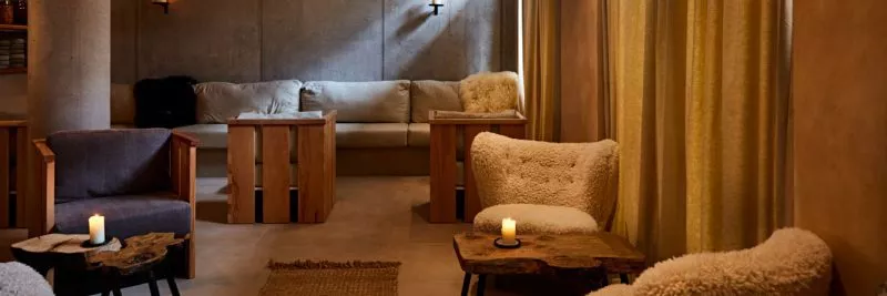 The interior of restaurant St. Barts, a view of the lounge with soft armchairs and sofas, the room has natural tones and wooden floors.